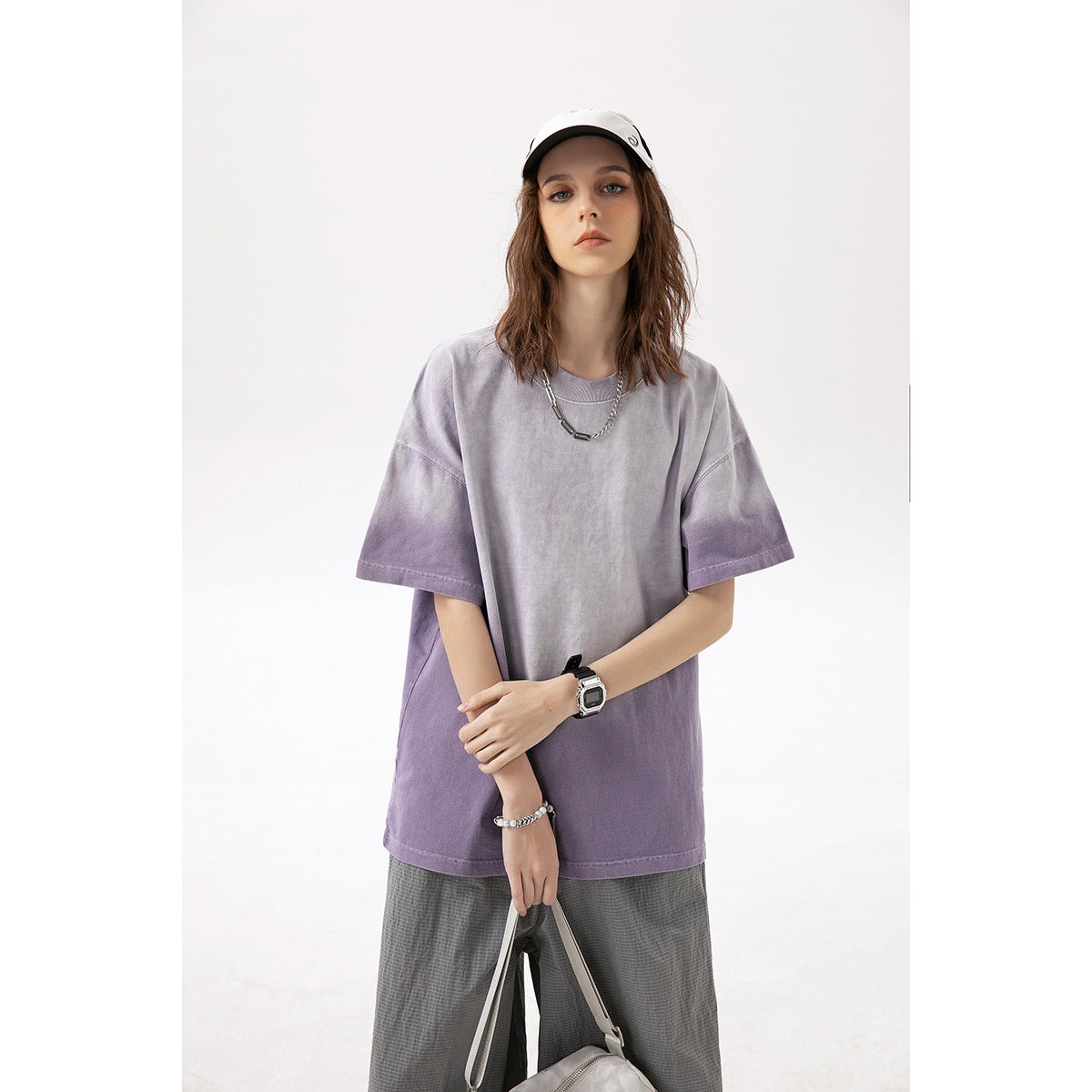 Model wearing an oversized lavender-gray washed T-shirt with darker purple shading toward the hem and sleeves.