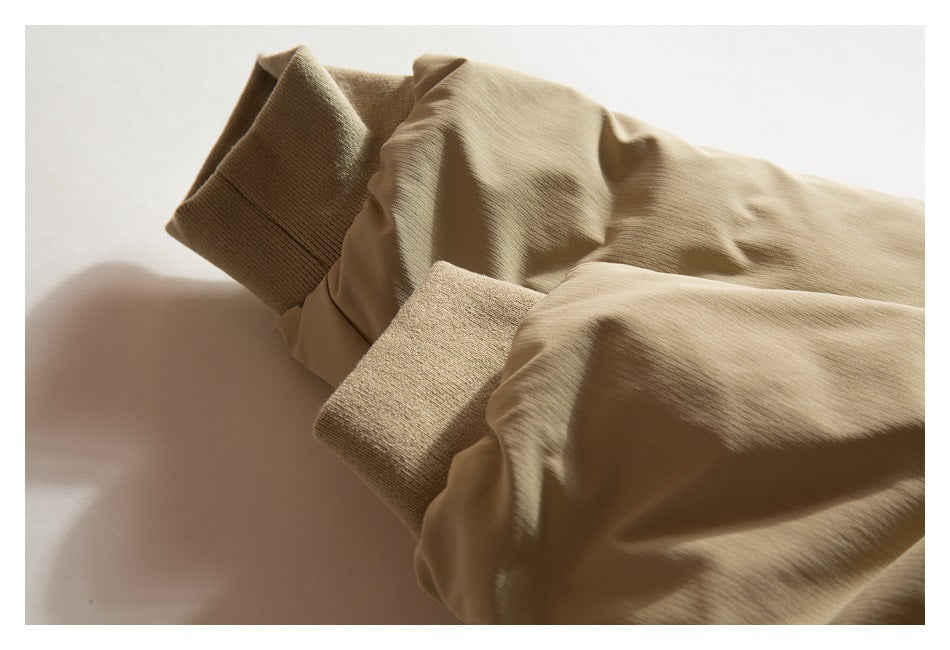 Close-up of tan jacket sleeves with wide ribbed knit cuffs.