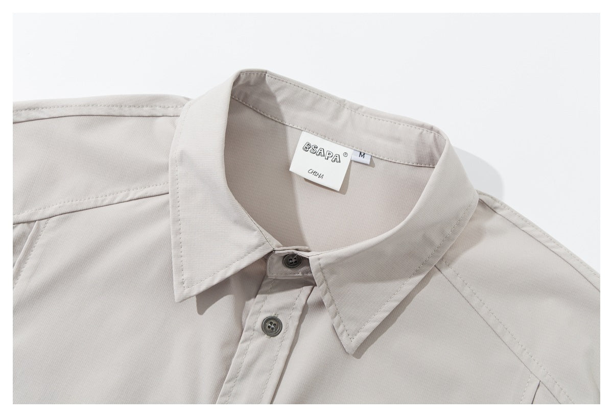 Close-up of the light beige shirt's pointed collar, top buttons, shoulder seams, and inner size and brand labels.
