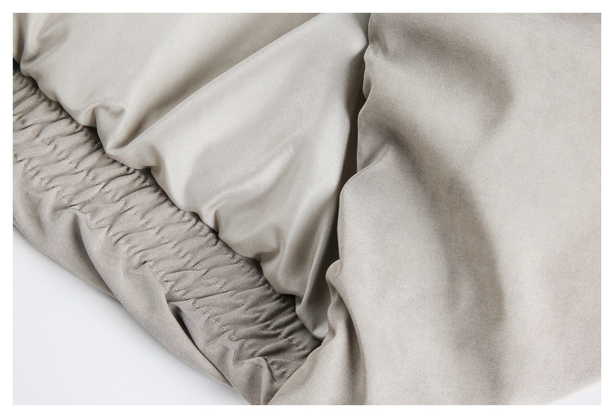 Close-up of a light gray jacket's gathered elastic hem and fabric.