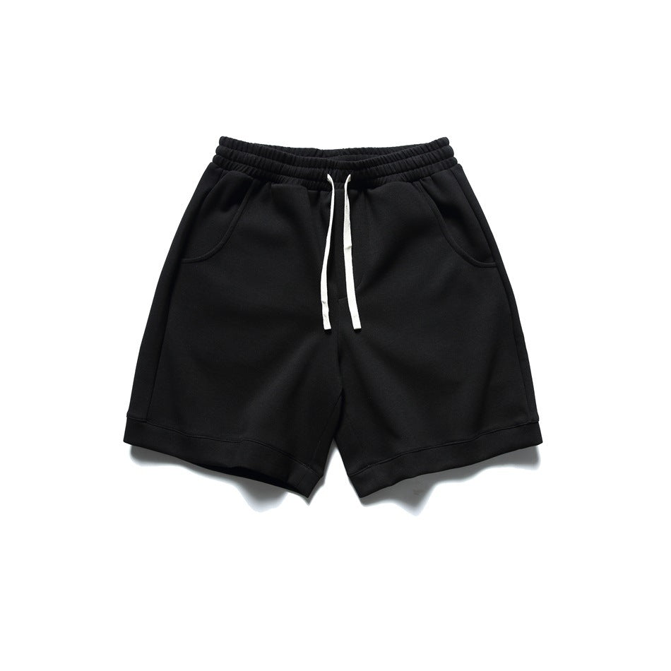 Black drawstring shorts with elastic waistband, side pockets and turned hems, flat lay front view