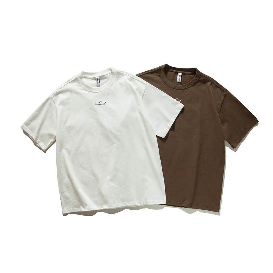 Front view of two short-sleeve crew-neck T-shirts, one ivory and one brown, with small chest graphics.