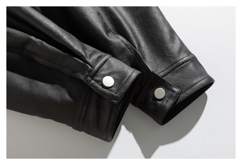 Close-up of black jacket cuffs with stitched snap tabs and round silver snaps.