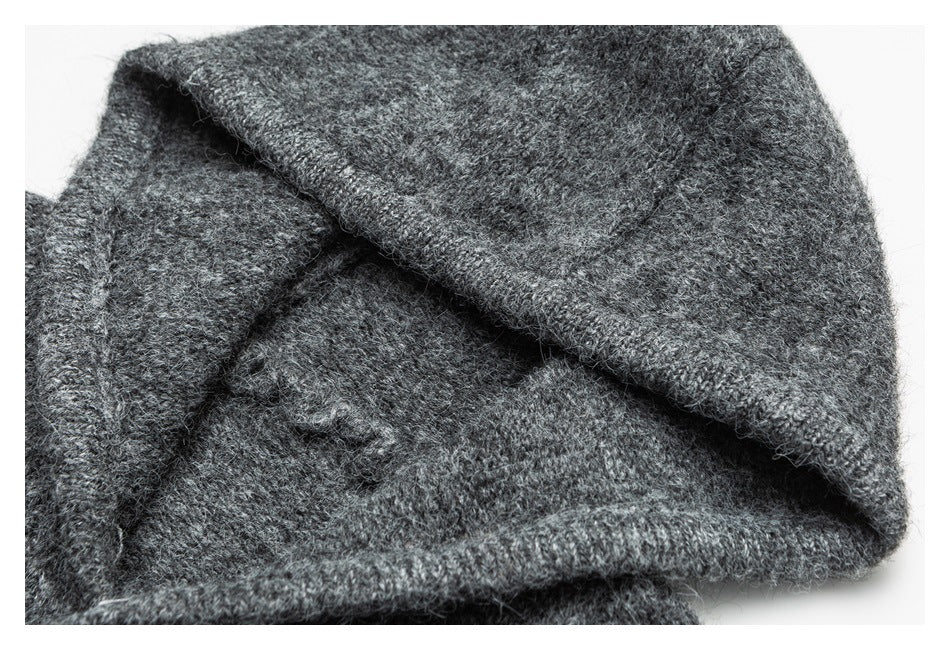 Close-up of a folded charcoal-gray knit garment with fuzzy yarn and a stitched edge.