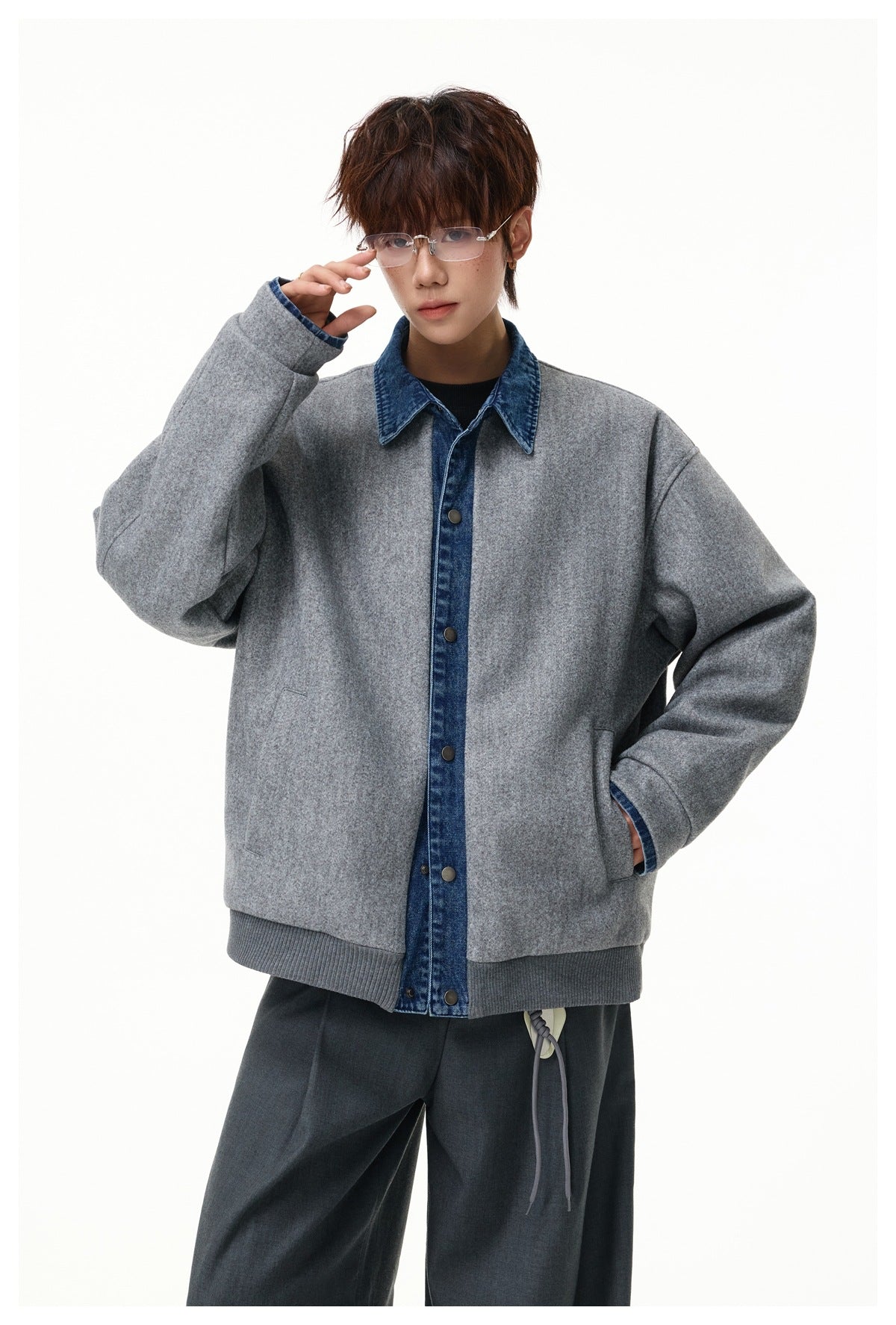 Model wearing gray wool-look jacket with blue denim collar and snap placket over a dark top, with gray trousers