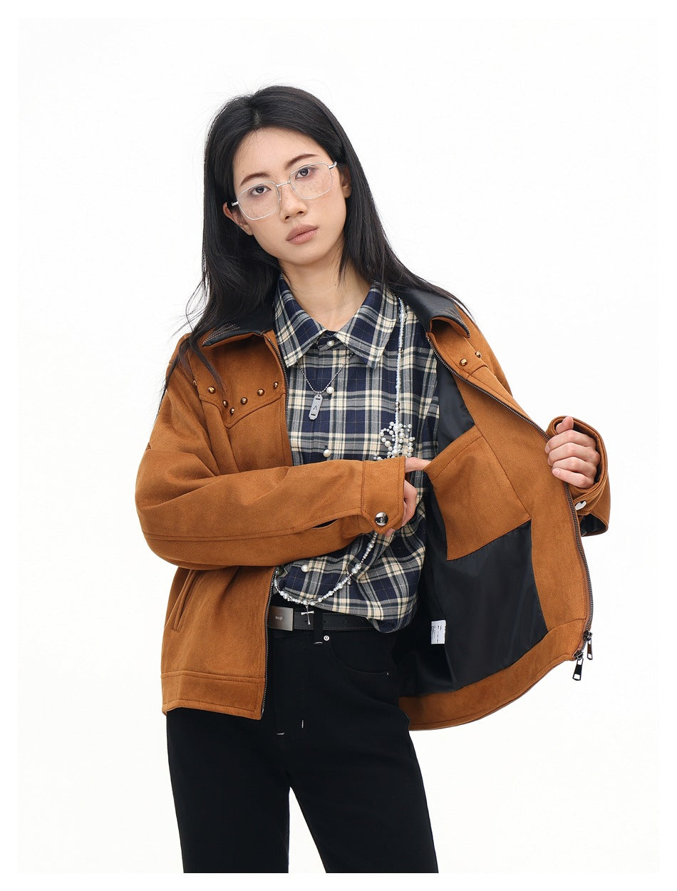 Model holds open a rust-brown jacket, showing the black lining over a navy plaid shirt.