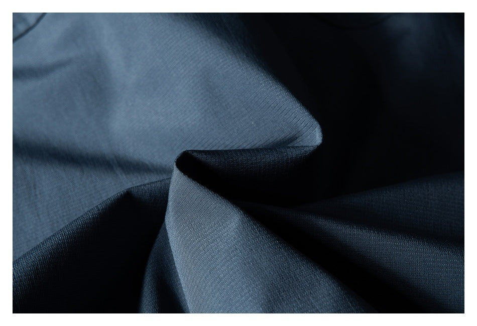 Close-up of dark blue fabric folded to show its fine surface texture.