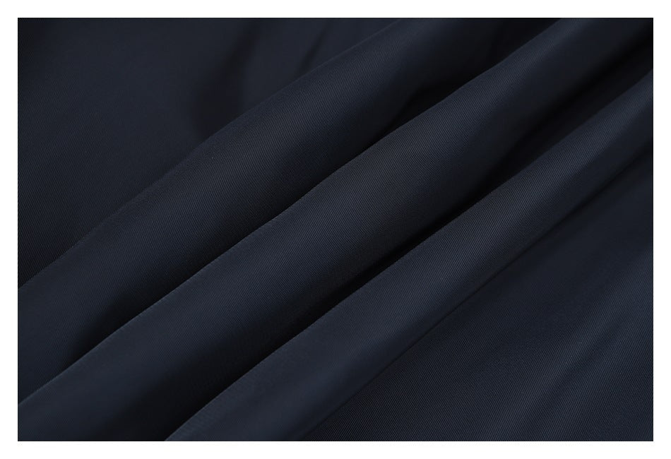 Close-up of dark navy fabric arranged in diagonal folds.