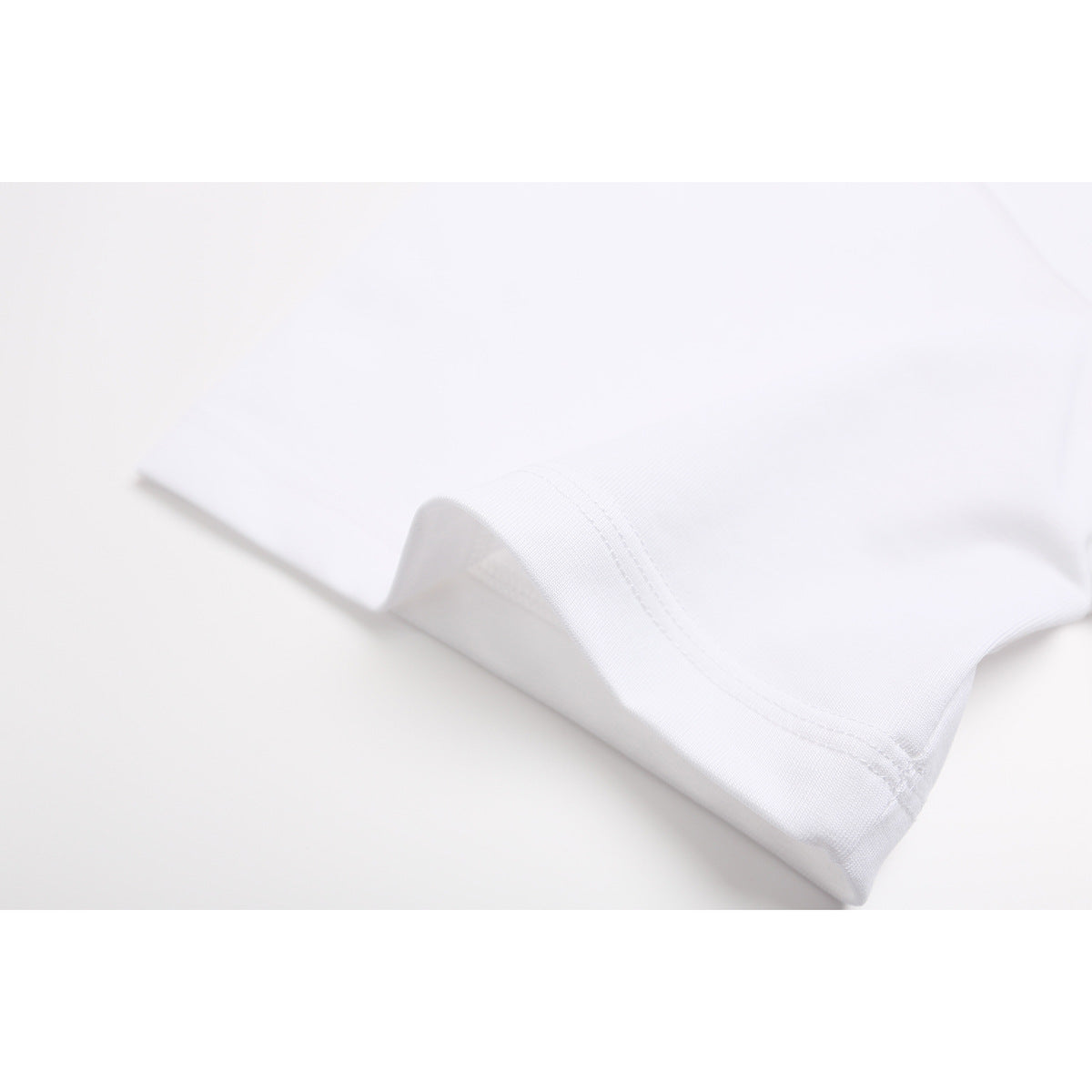 Close-up of the white T-shirt sleeve edge with visible double-stitched hem.