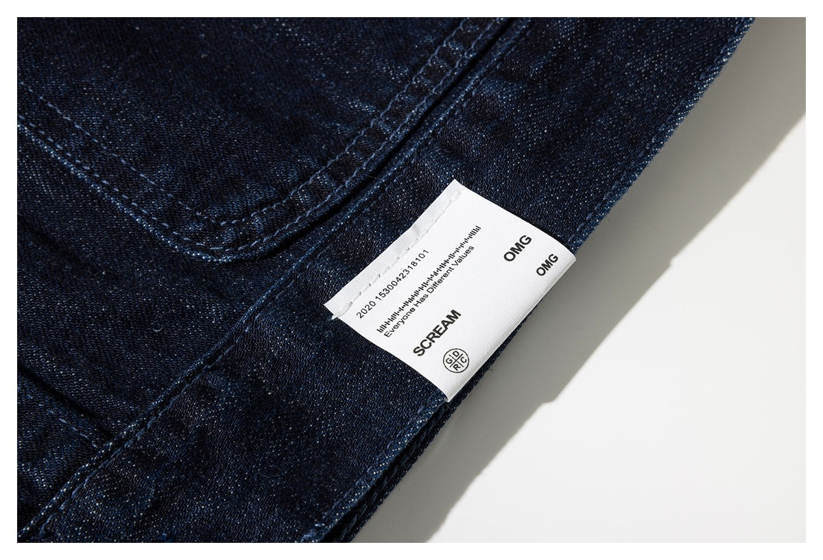 Close-up of a white English-text label attached to dark indigo denim.
