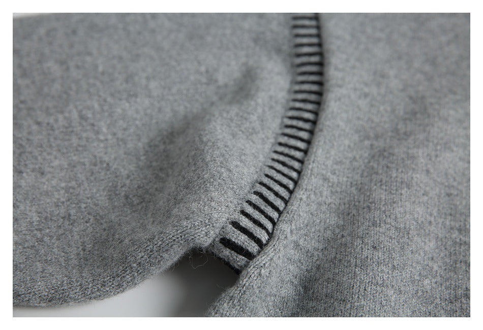 Close-up of gray knit fabric with black ladder-like stitching along a folded edge.