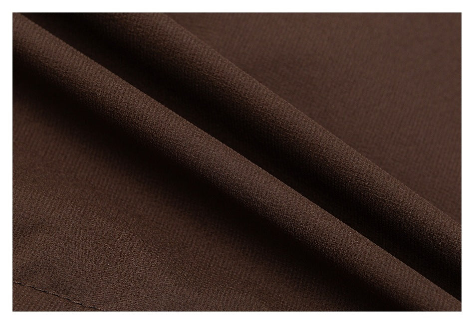 Macro view of brown jacket fabric folded to show its textured surface.