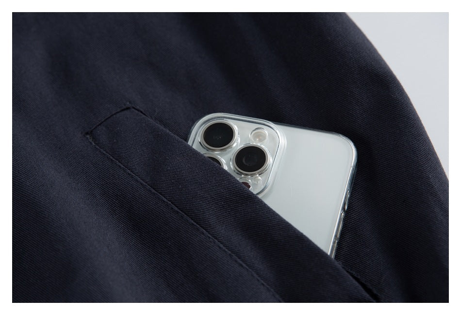 Close-up of a dark navy garment pocket holding a silver smartphone.