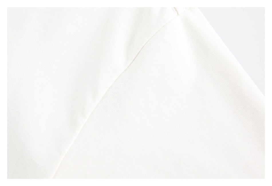 Close-up of a seam and folded edge on plain white fabric.