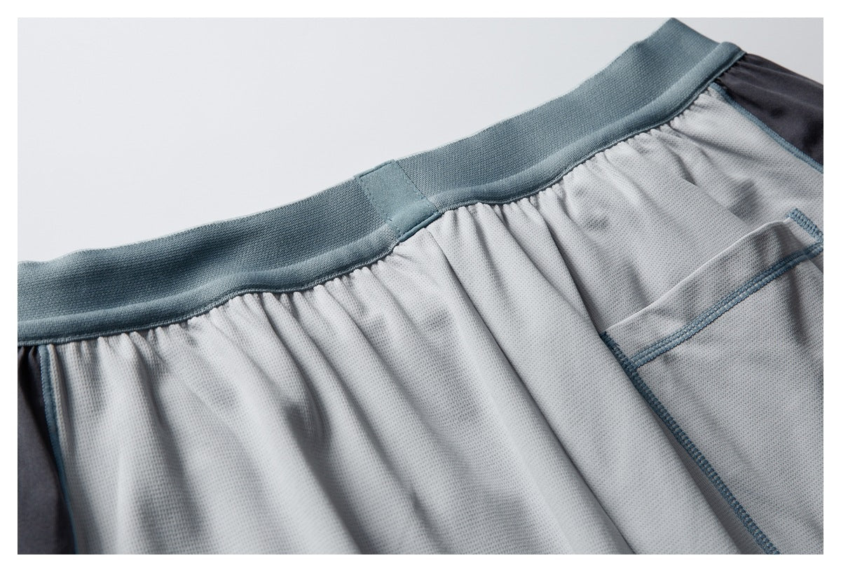 Close-up of a blue-gray waistband and gathered light gray mesh fabric with blue seams.