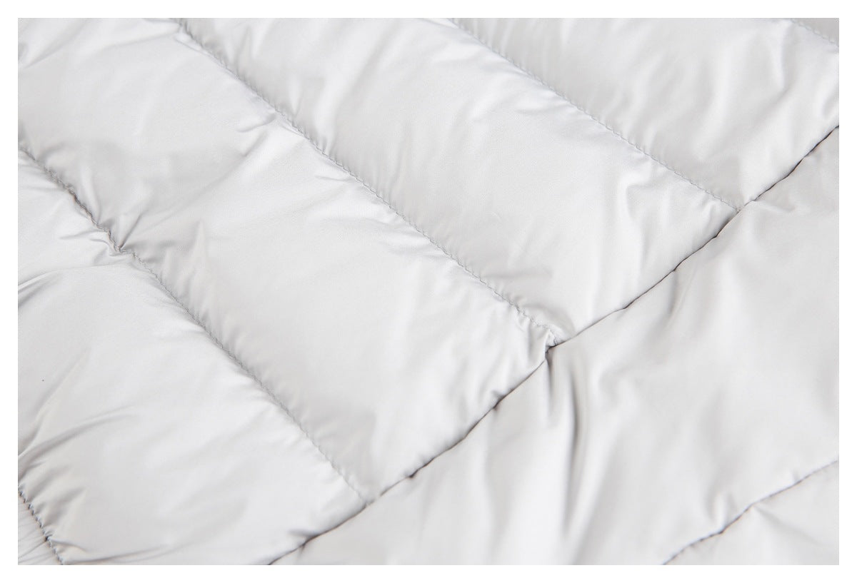 Close-up of diagonal quilted seams and padded panels on a light gray garment.