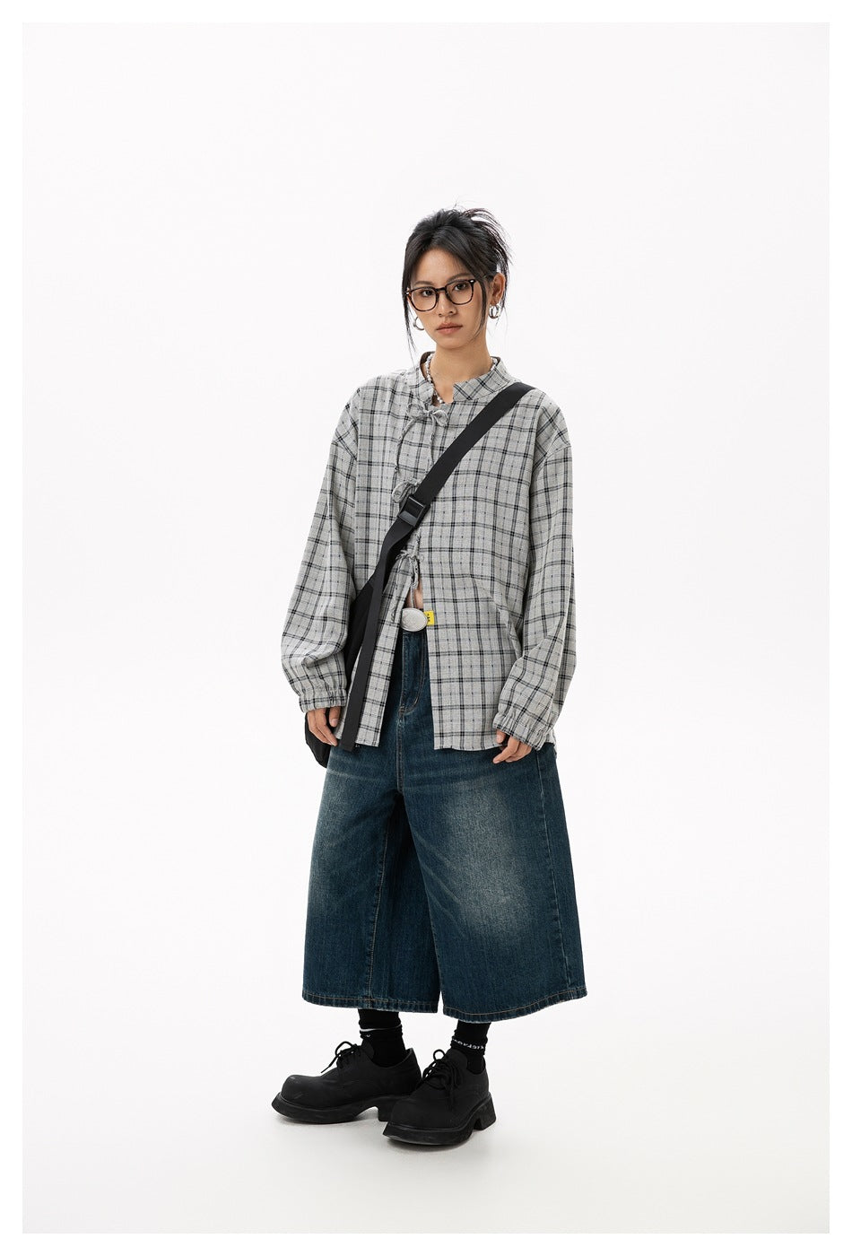 Full-length front view of a model wearing a gray plaid tie-front blouse and dark wide-leg cropped jeans.