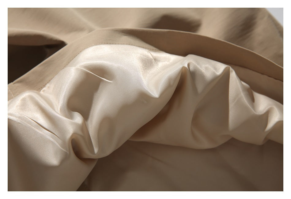Close-up of the jacket's shiny pale lining gathered beneath a beige edge.