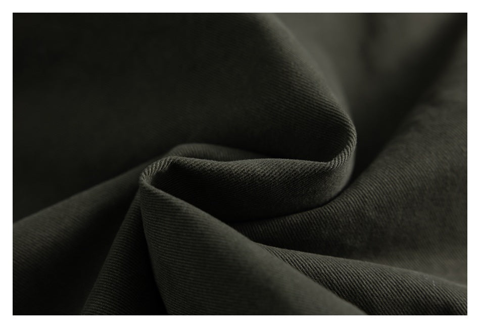 Macro view of dark olive fabric folded to show its fine diagonal weave.