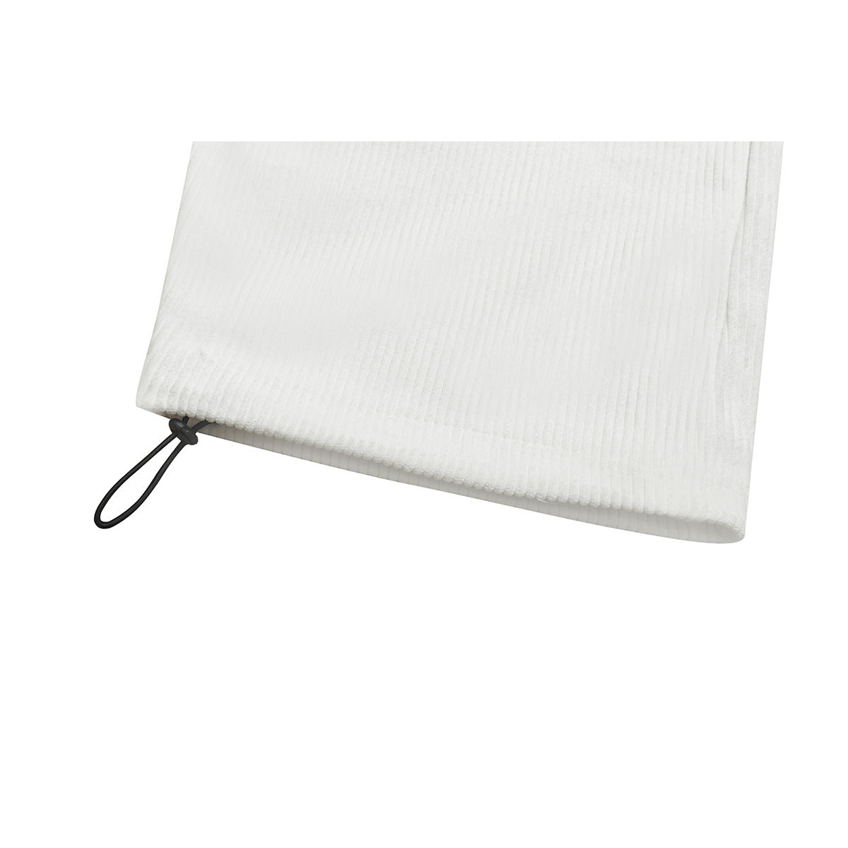 Close-up of the ribbed hem of white pants with a black cord loop and toggle.