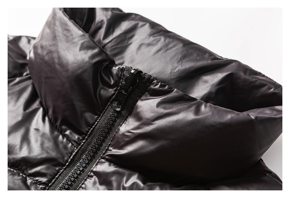 Close-up of a glossy black padded jacket with a chunky black zipper.