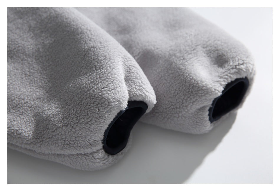 Close-up of two dark-edged openings in the light gray fleece garment.