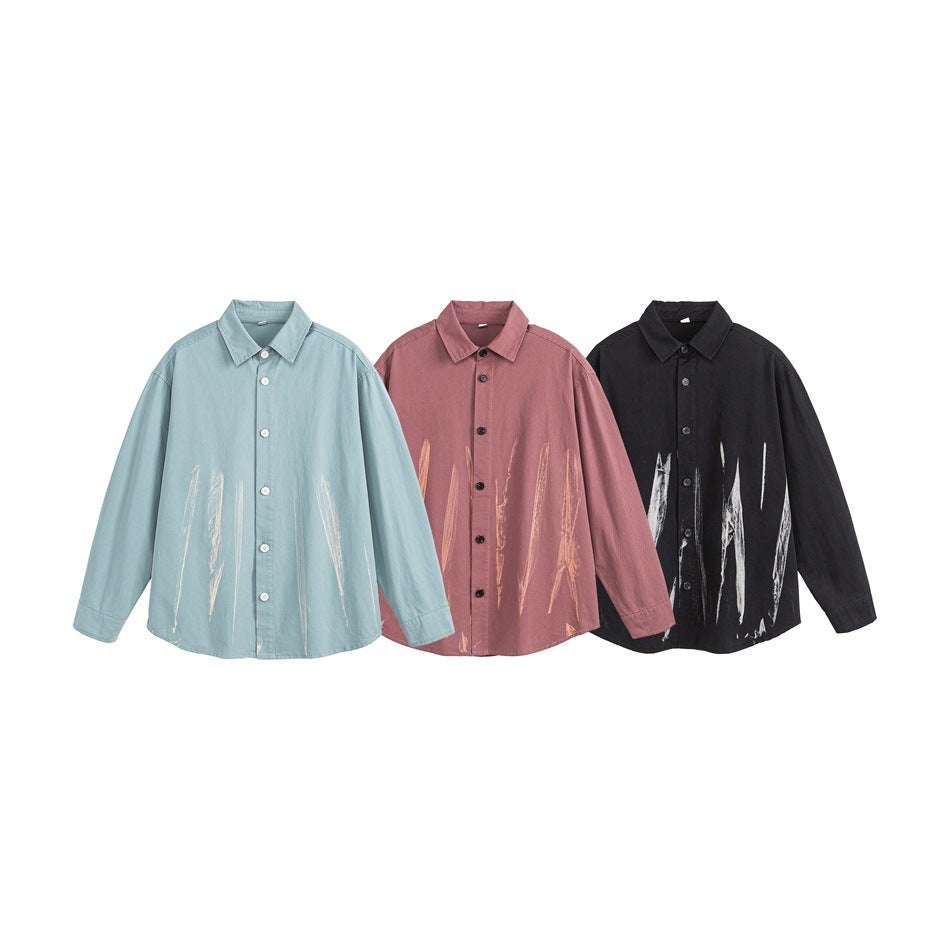 Three button-up shirts shown together in pale blue, dusty rose, and black, each with brushstroke graphics.