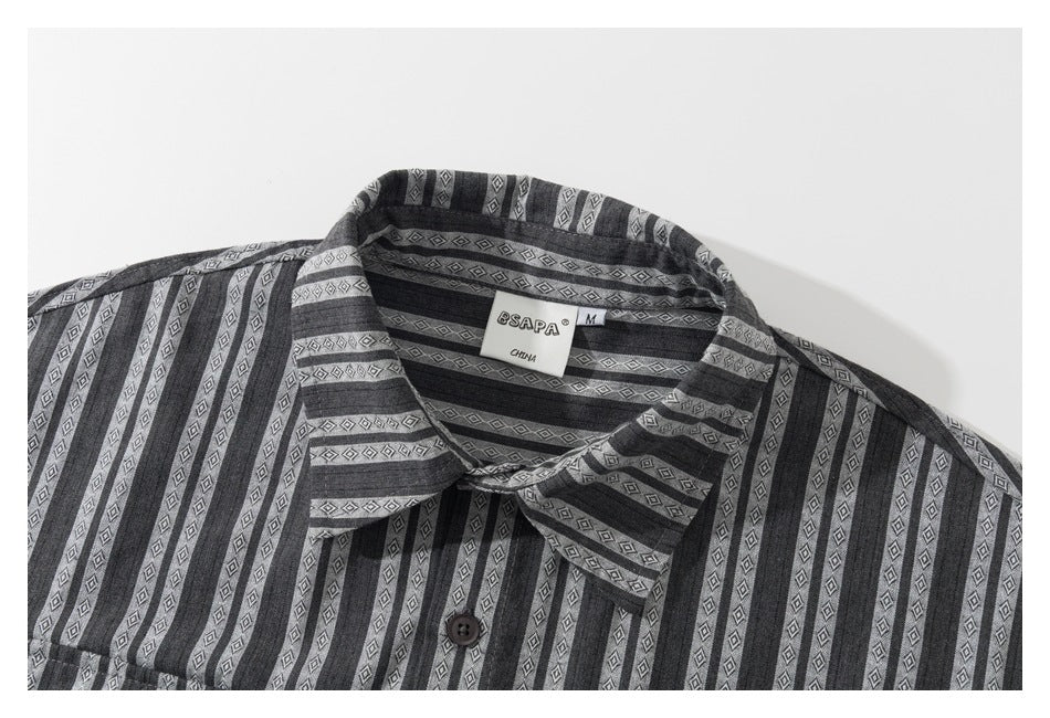Close-up of a charcoal gray striped shirt collar, diamond-patterned fabric, button, and neck label.
