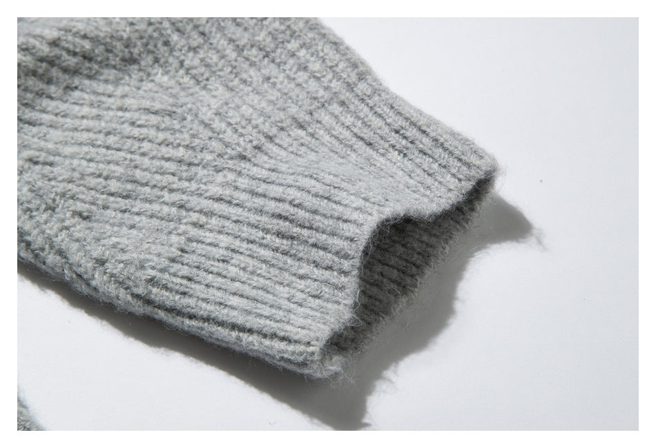 Close-up of a ribbed cuff on a light gray knit sleeve.
