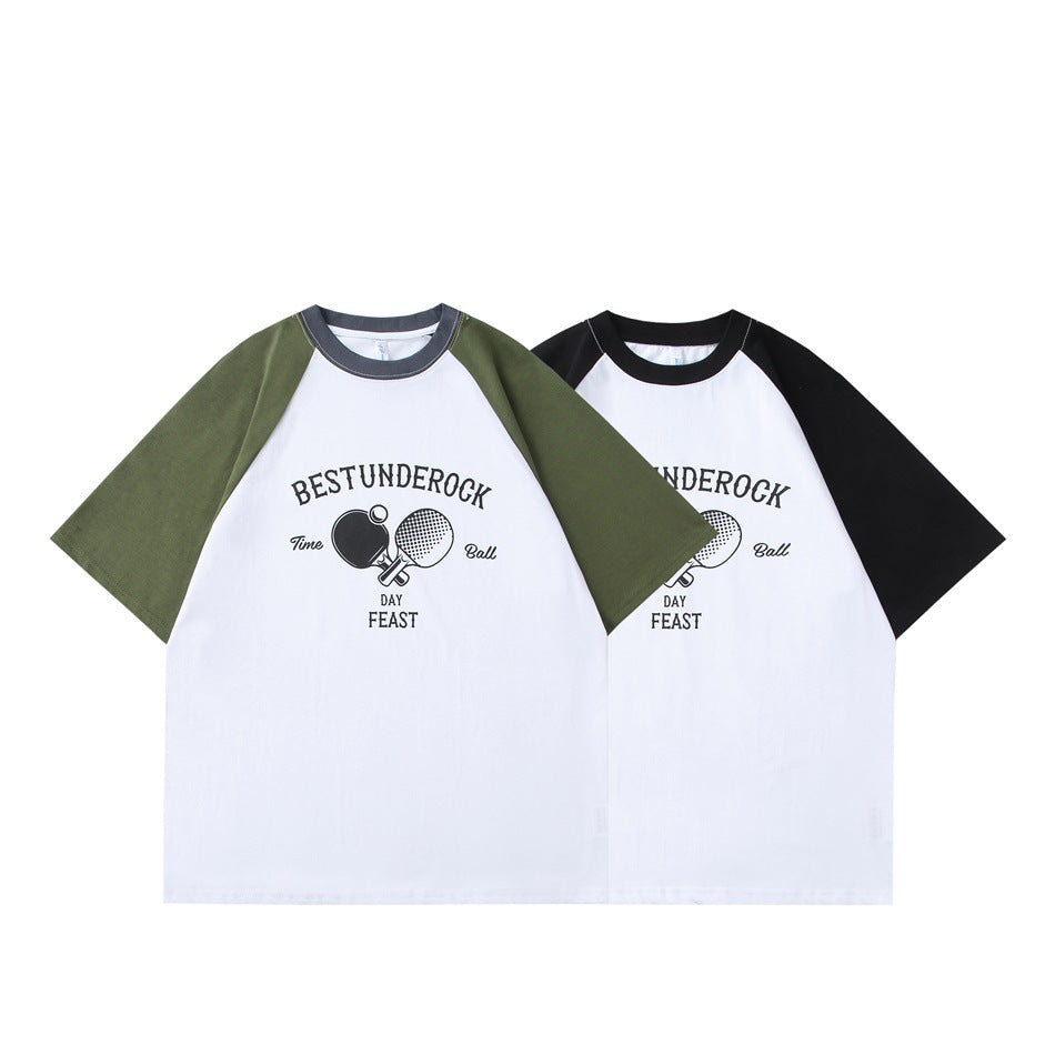 Two white raglan T-shirts with ping-pong graphics, one with olive sleeves and one with black sleeves.