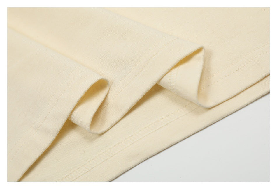 Close-up of cream fabric showing a folded hem and parallel rows of stitching.