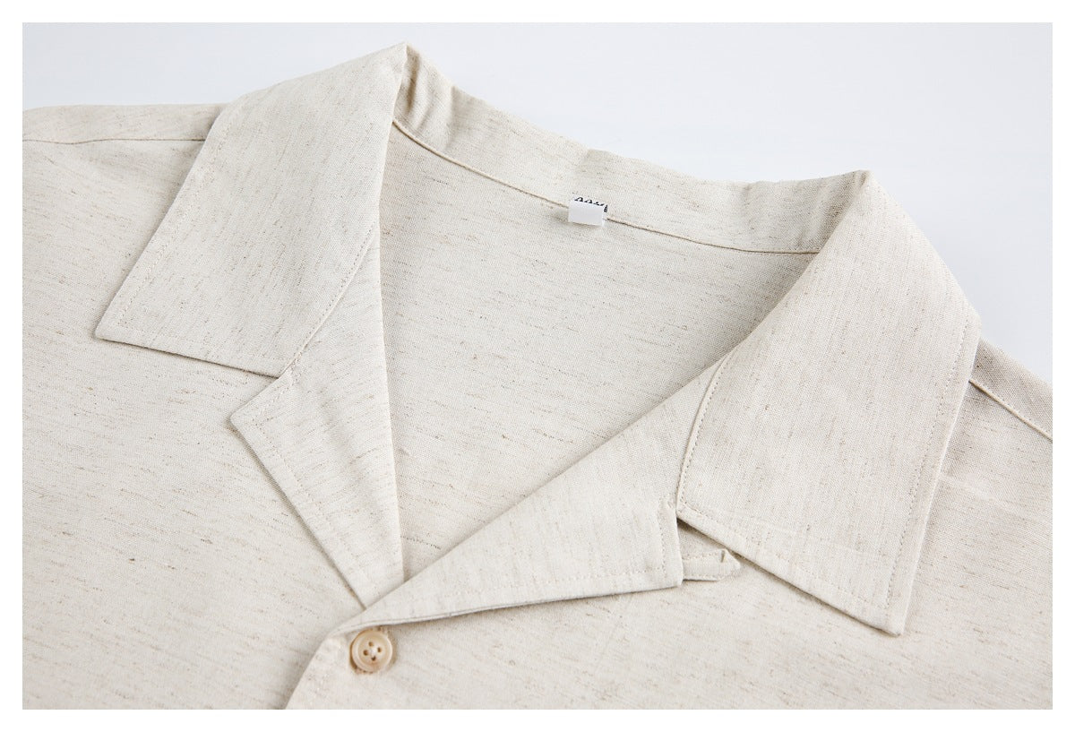 Close-up of the cream shirt's wide open collar, neckline, and top button.