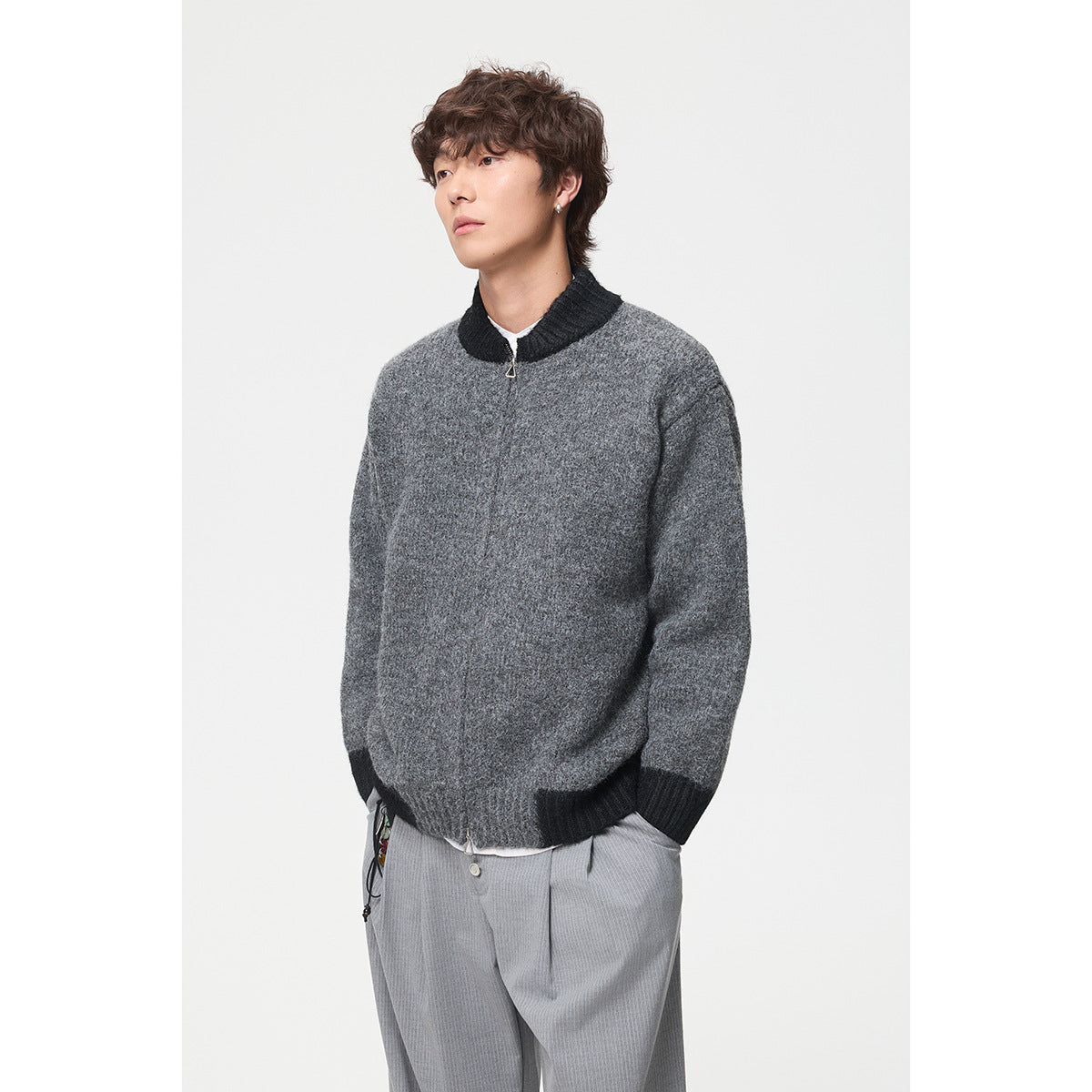 Model wearing a dark gray zip-front knit jacket with a black ribbed collar, cuffs and hem.