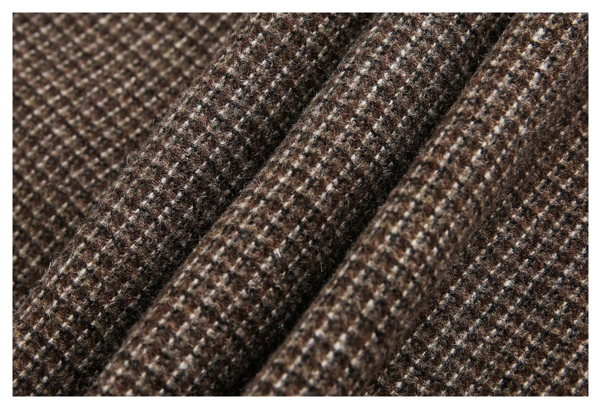 Close-up of brown, cream, and dark-speckled fabric arranged in soft folds.