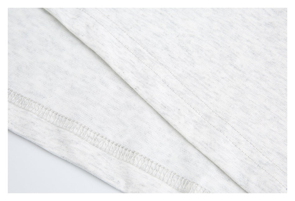 Close-up of the white heathered shirt's stitched hem and seam.