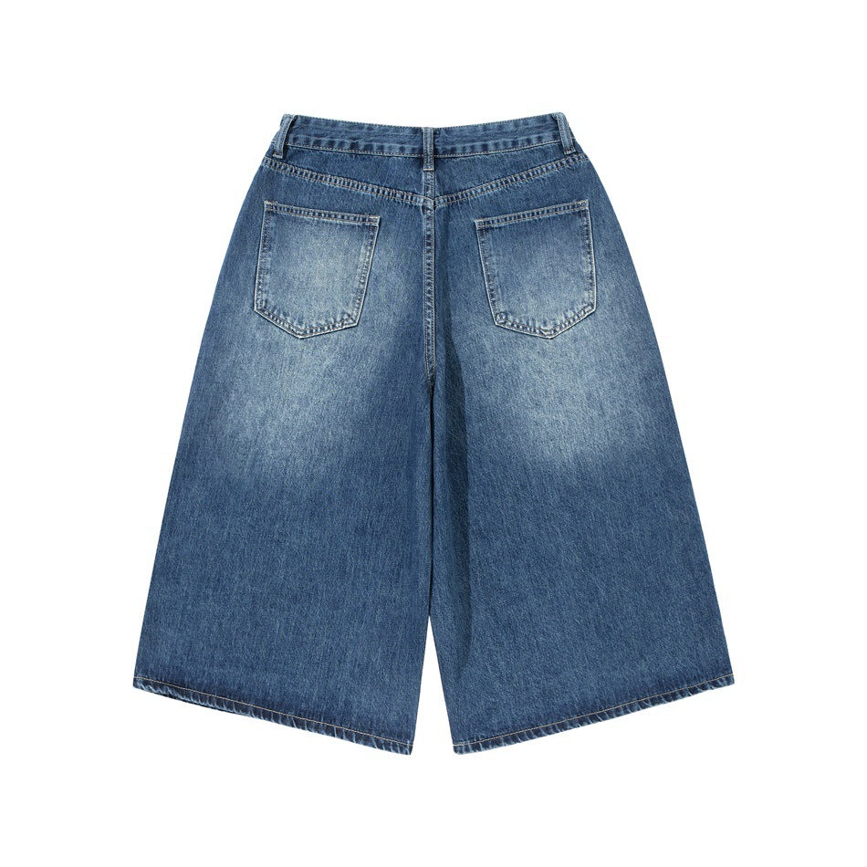 Back view of dark blue wide-leg denim shorts with two rear pockets and faded wash.