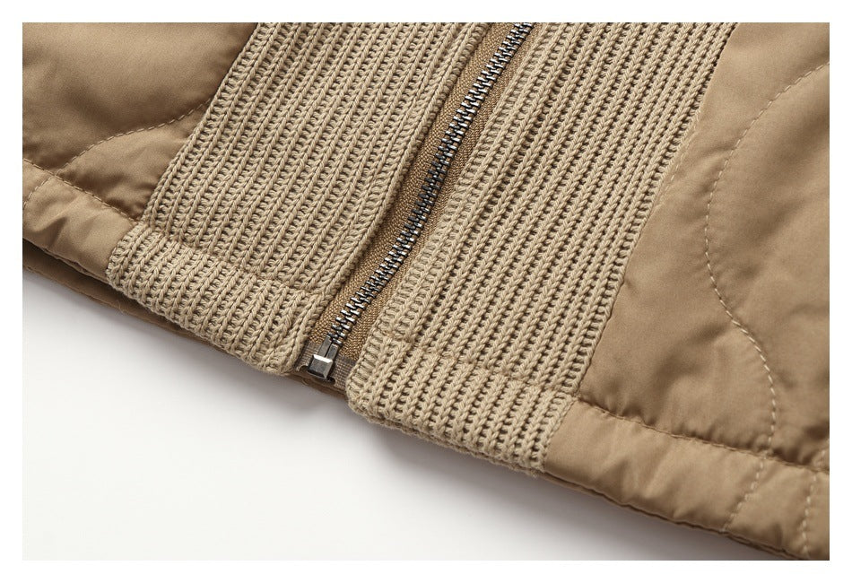 Close-up of the metal front zipper and ribbed knit panels at the hem of a tan jacket.