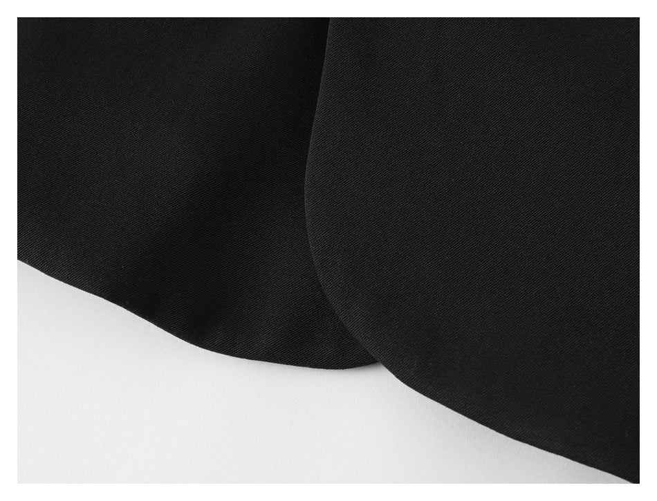Close-up of the curved lower edges and overlapping panels of a black jacket.