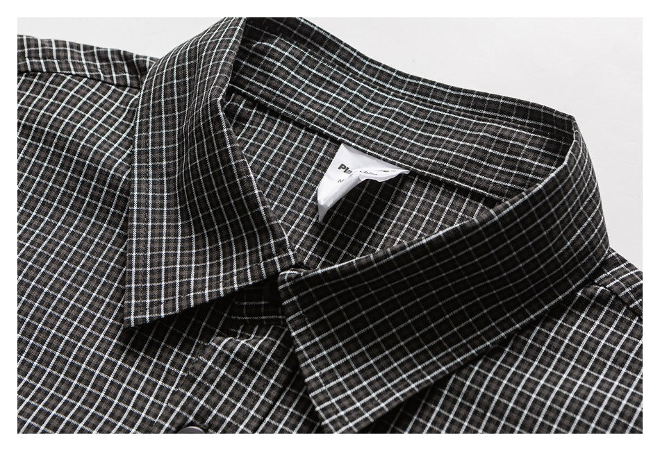Close-up of a black checked shirt collar with a small white neck label.