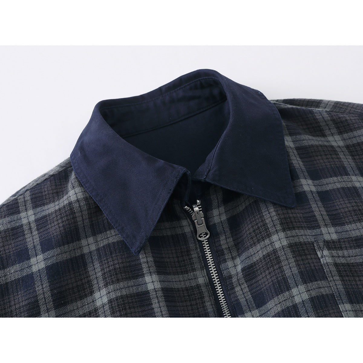 Close-up of a navy collar and silver zipper on a dark blue and gray plaid jacket.