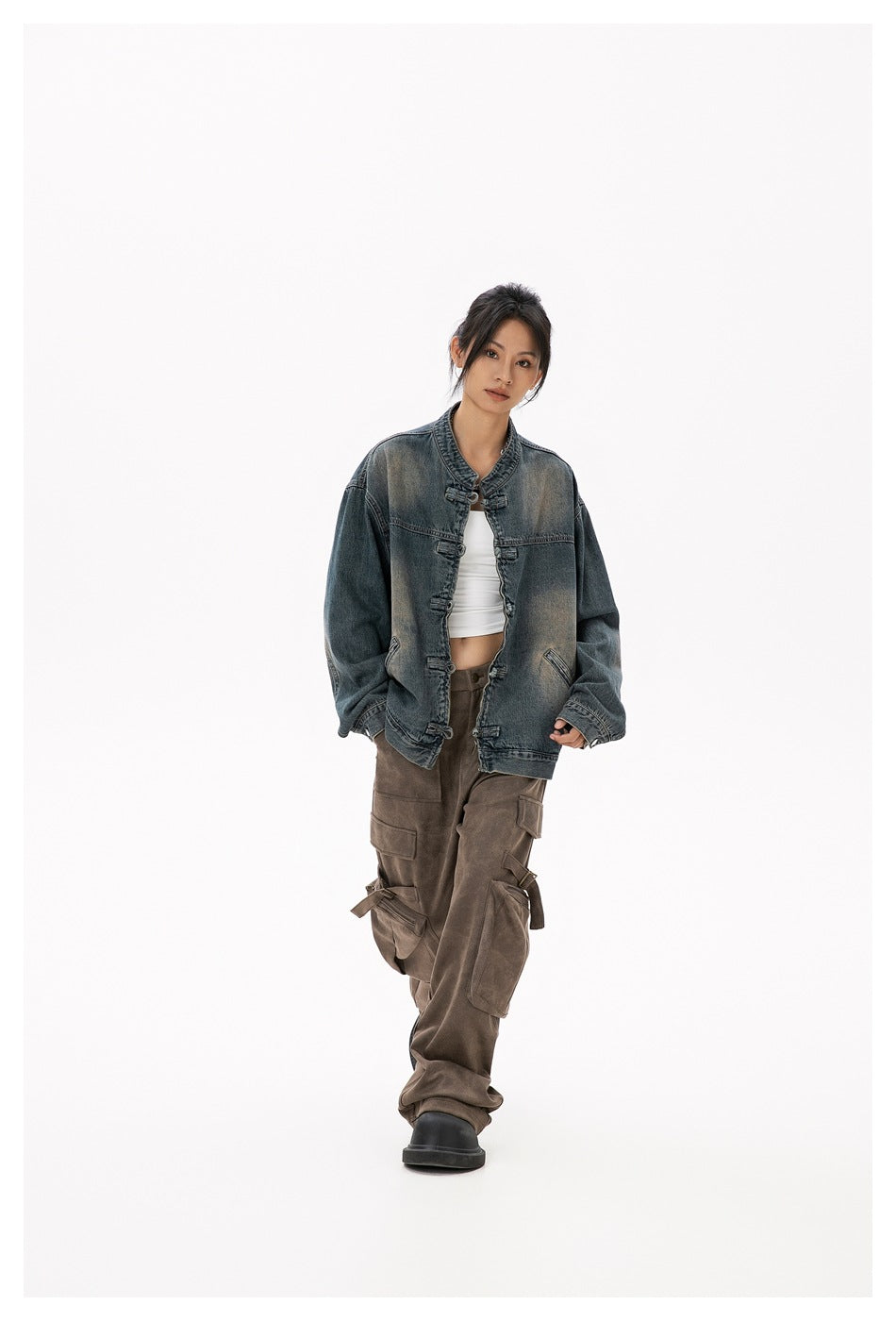 Model wearing a faded blue-gray denim jacket with frog closures and brown cargo pants, front view.