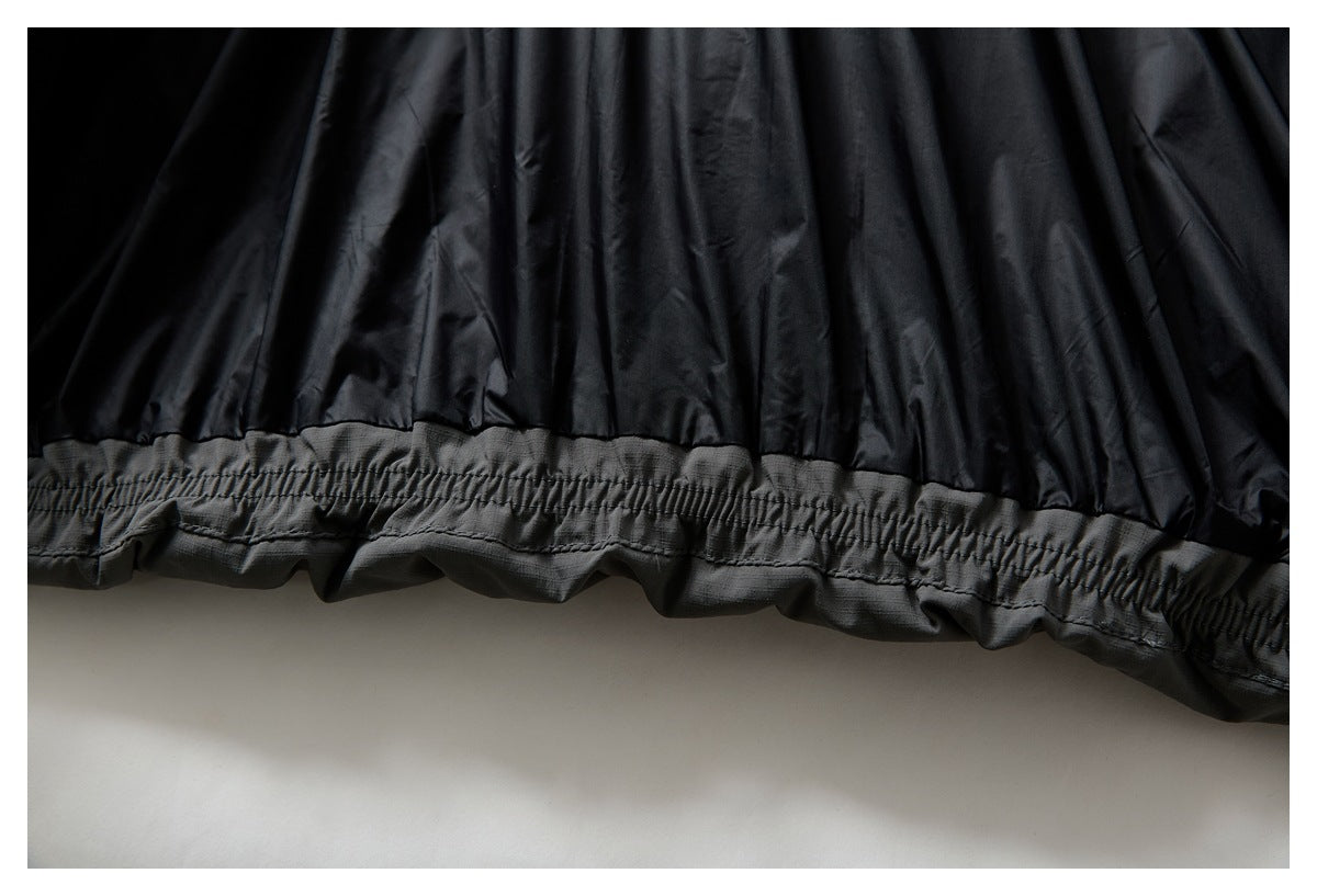 Close-up of a black jacket's gathered gray hem band.
