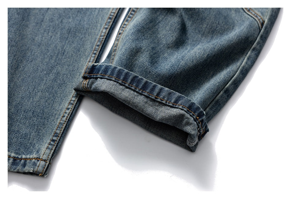 Close-up of a turned-up jeans cuff, showing the denim underside and contrasting stitching.