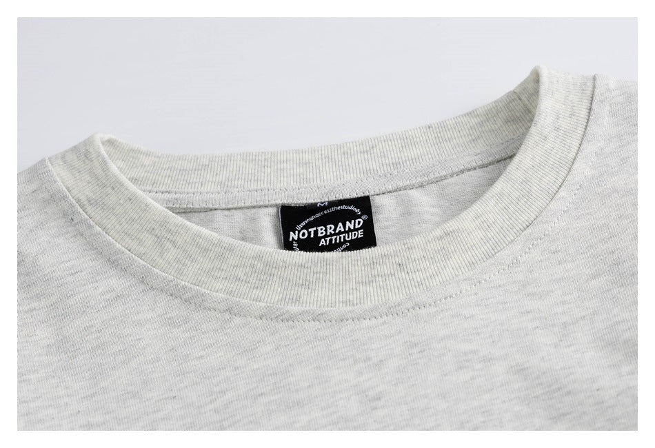 Close-up of the light gray T-shirt's ribbed crew neck and black neck label.