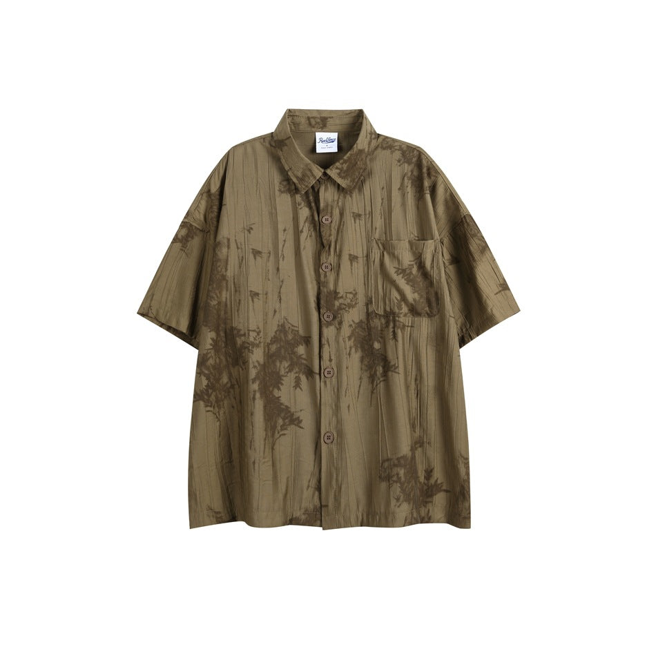 Khaki-green short-sleeve button-up shirt with crinkled texture, chest pocket and dark brown bamboo-leaf print, flat lay