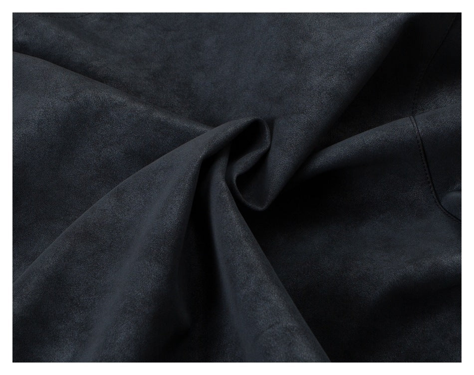 Close-up of dark charcoal fabric draped into folds, with a curved stitched seam visible at the right.