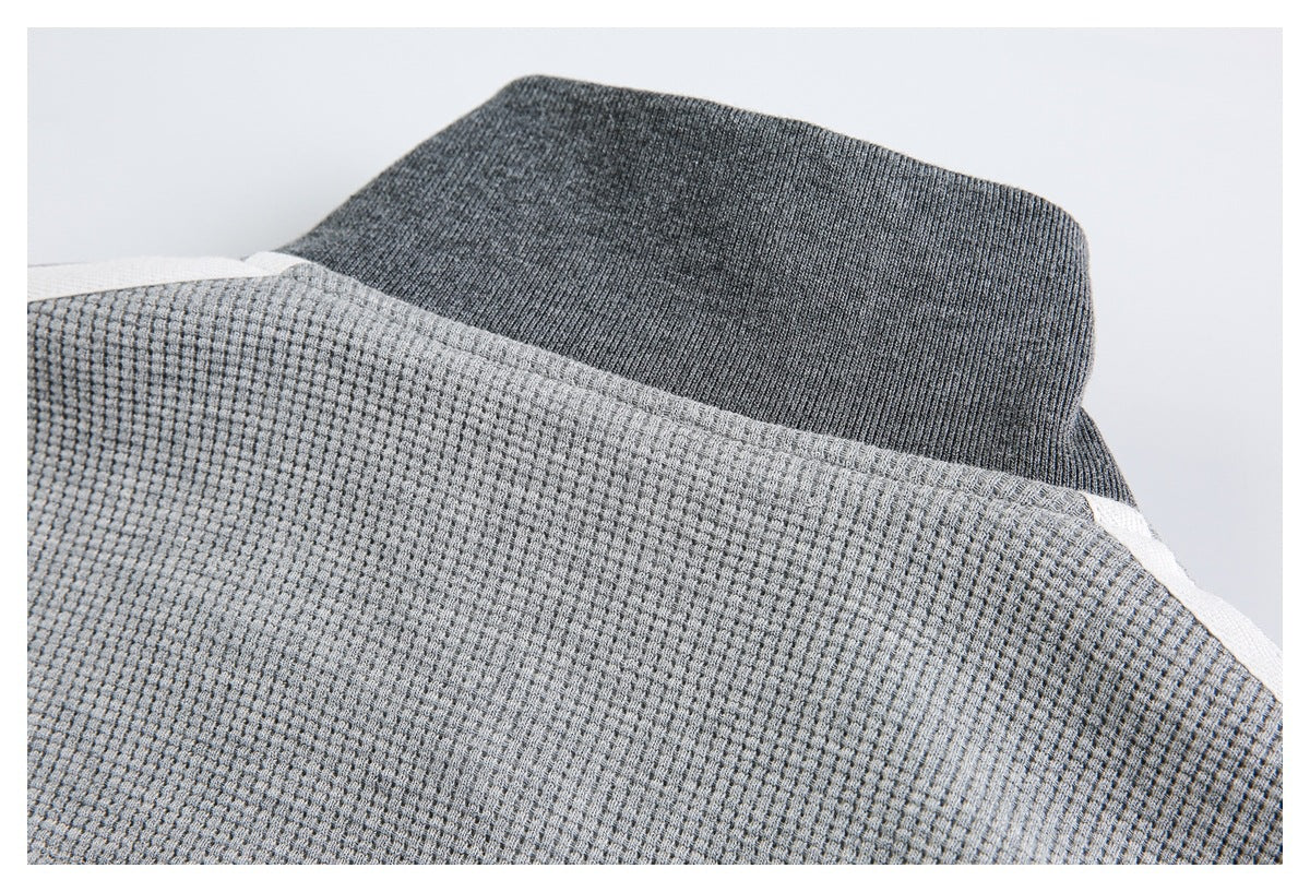 Close-up of a dark charcoal ribbed collar against light gray textured fabric.