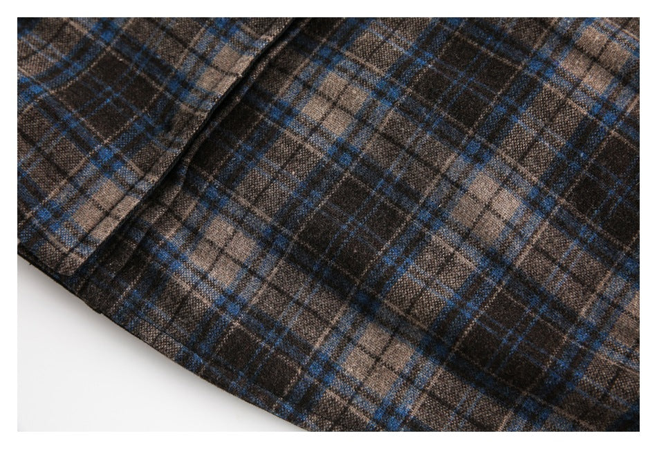 Close-up of the edge and stitching on brown, charcoal, and blue plaid fabric.