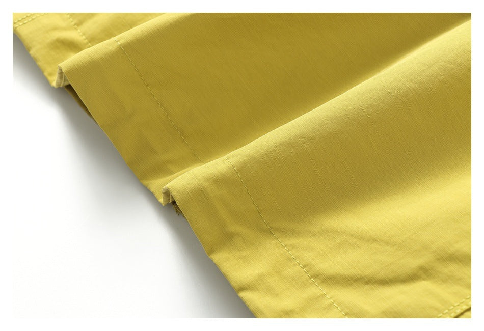 Close-up of a yellow jacket hem with parallel rows of stitching.