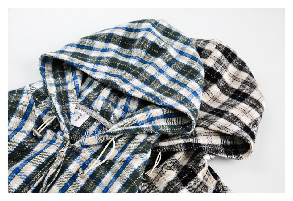 Two plaid hooded zip-up jackets laid together, one blue, cream and dark green, the other black and cream.